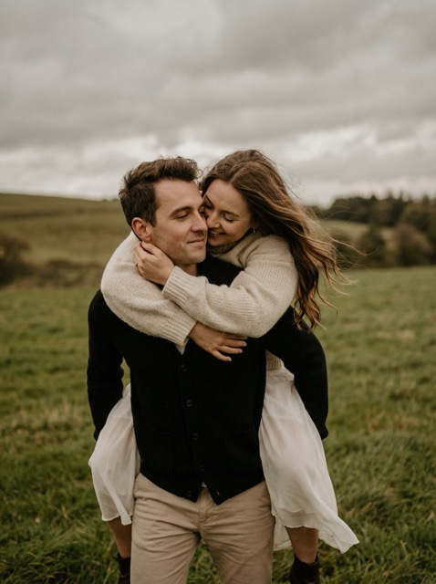 VideoDraft: Romantic couple in a windy field, intimate and carefree.